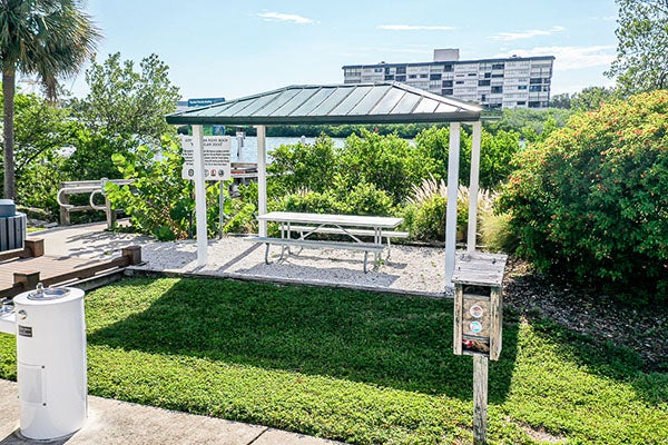covered picnic table next to water fountain
