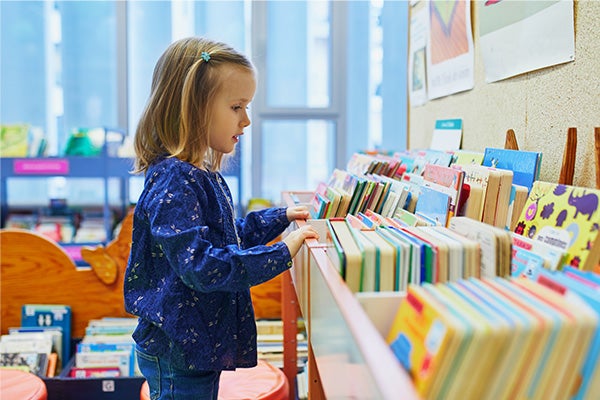 little girl checking out board books