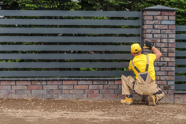 Man building a horizontal fence.
